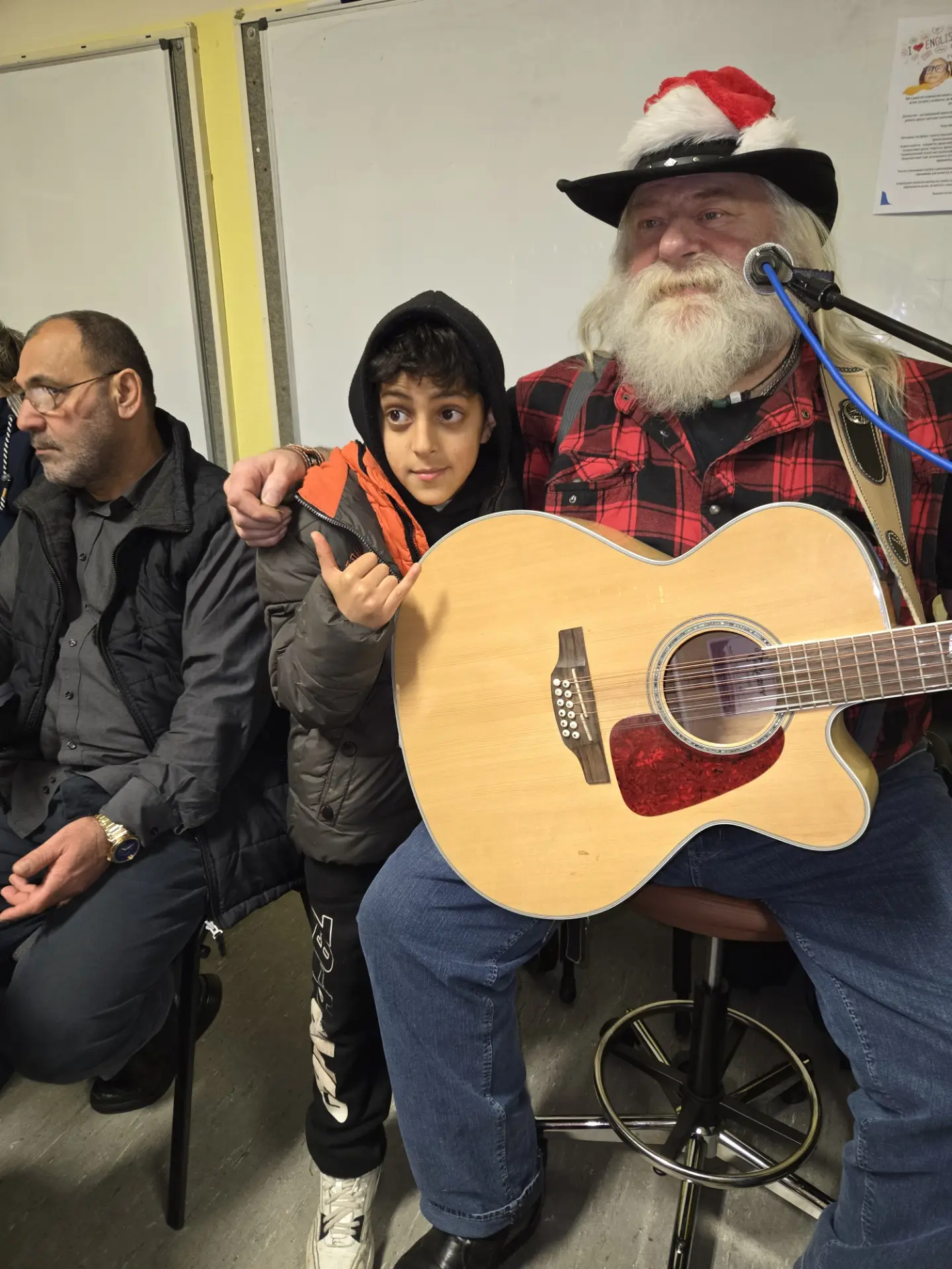Musiker mit Gitarre und ein Junge bei der Weihnachtsfeier